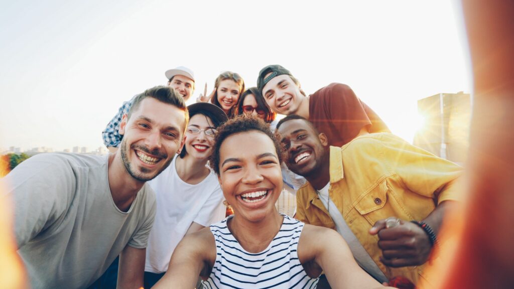 pexels-photo-36729918-36729918 A diverse group of friends taking a joyful selfie outdoors during sunset.